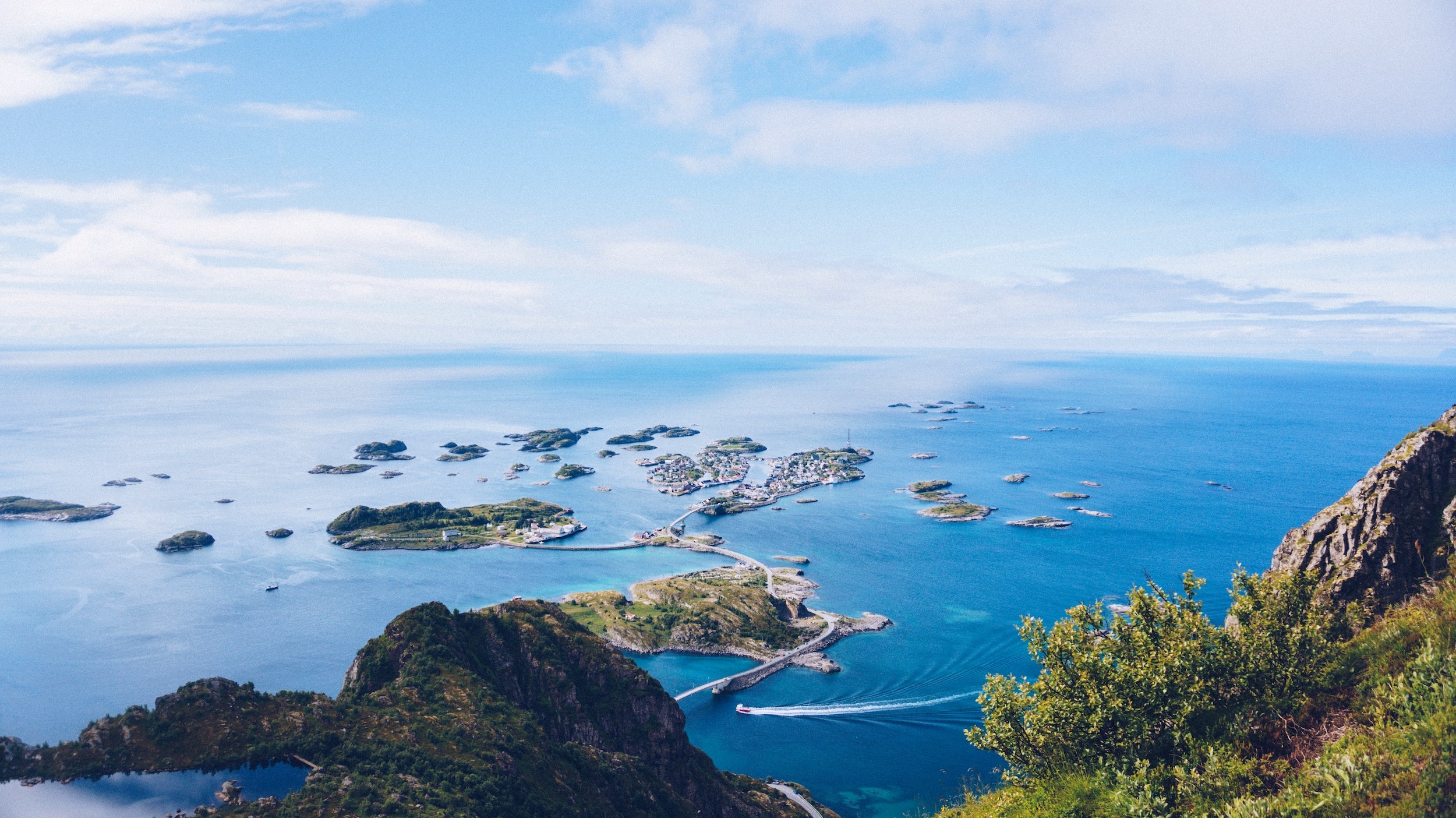 Lanskapdsbilde av Norge med utsikt over øyer, sjø og fjell.