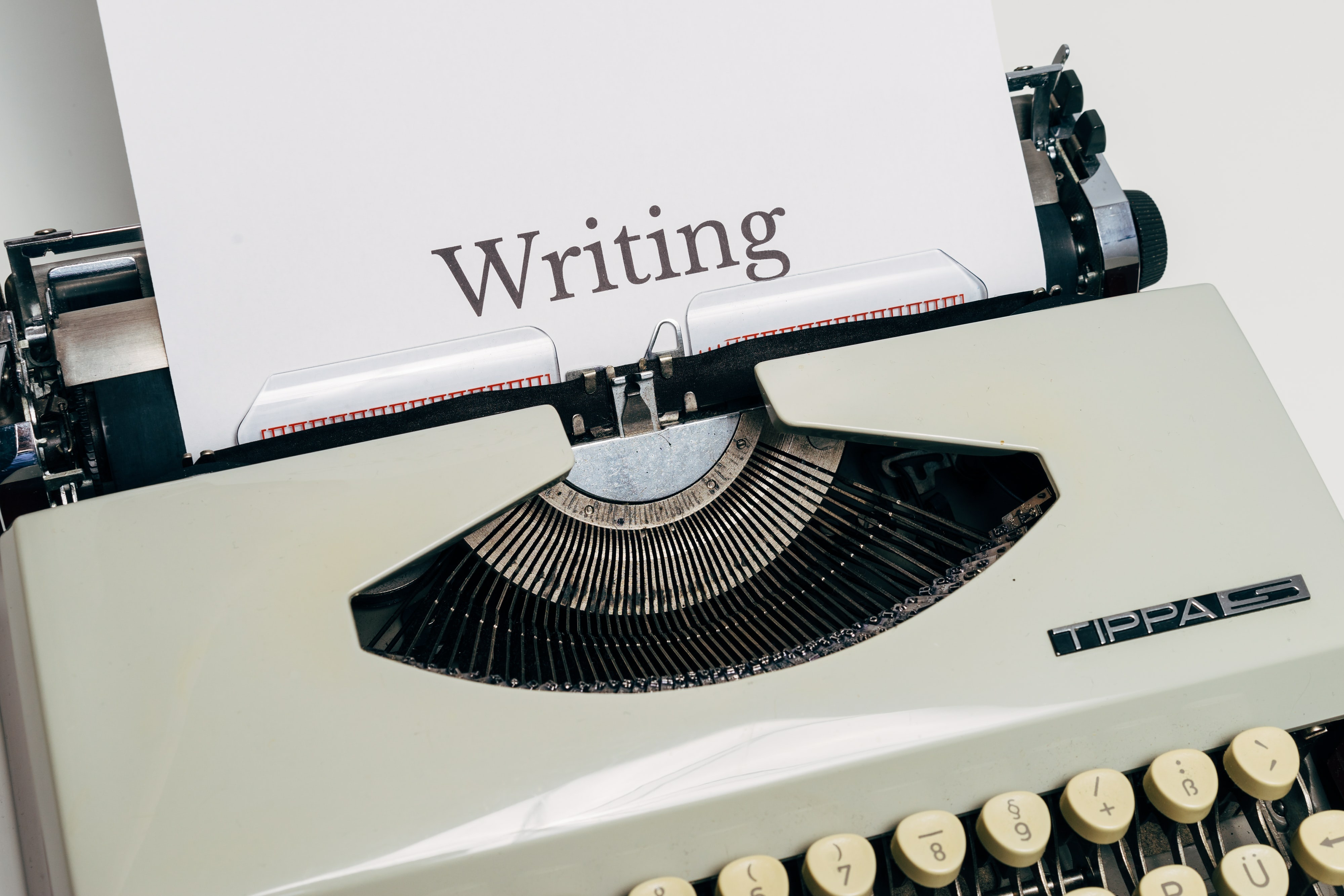 Gammel skrivemaskin, hvor det er ark det står Writing på (skrive på norsk).