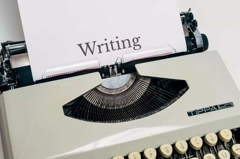 Gammel skrivemaskin, hvor det er at ark det står Writing på (skrive på norsk).