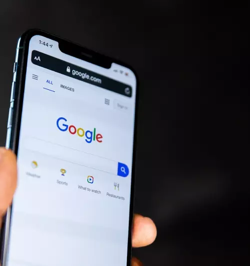 En mobil holdes opp og viser frem Google søkefelt.