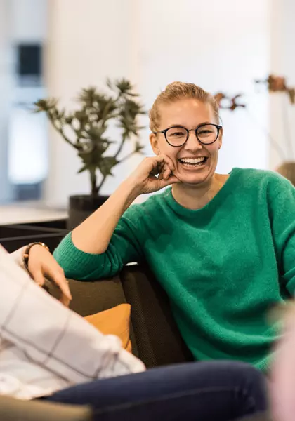 Bilde av tre ansatte i et kontorlandskap som snakker sammen og smiler