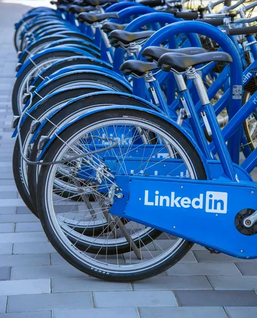 Sykler stående på en rekke med LinkedIn logo på seg.